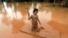 A girl uses a mattress as a raft during the flood after the Xe Pian Xe Namnoy hydropower dam collapsed in Attapeu province, Laos July 26, 2018.
