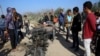 FILE - In this Monday, Nov. 12, 2018 file photo, Palestinians inspect a vehicle that was destroyed in an Israeli raid that killed seven Hamas Palestinian militants, including a local Hamas commander, late Sunday, east of Khan Younis, southern Gaza Strip.
