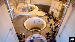 FILE - In this photo released by the Atomic Energy Organization of Iran, technicians work at the Arak heavy water reactor's secondary circuit as officials and media visit the site, near Arak., Dc. 23, 2019.