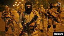 FILE - A still image taken from an Islamic State video released through the group's Amaq news agency shows an unidentified militant addressing the camera. The video was said to have been shot in Mosul, Iraq, on Oct. 18, 2016.