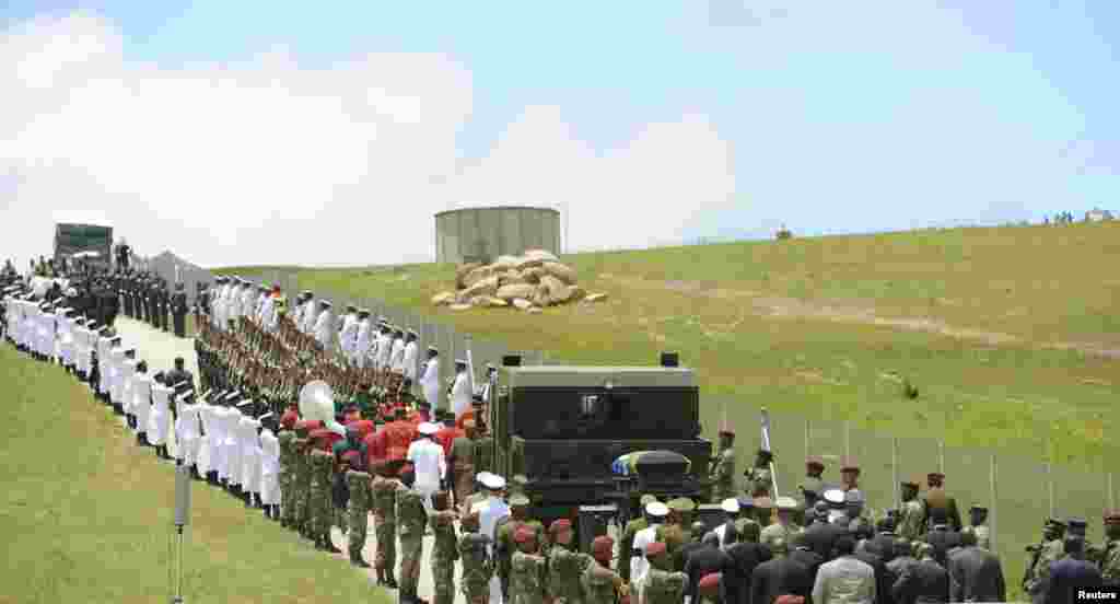 The coffin of Nelson Mandela is escorted by the military to the funeral in Qunu, Dec. 15, 2013. 