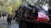 Afghans check a car destroyed by an attached bomb in Kabul, Afghanistan, Nov. 7, 2020.