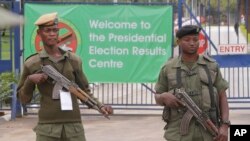 Des officiers armés gardent un bureau de comptage pendant l'élection présidentielle à Lusaka, Zambie, le 21 janvier 2015.