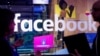 Conference workers speak in front of a demo booth at Facebook's annual F8 developer conference, Tuesday, April 18, 2017, in San Jose, California.