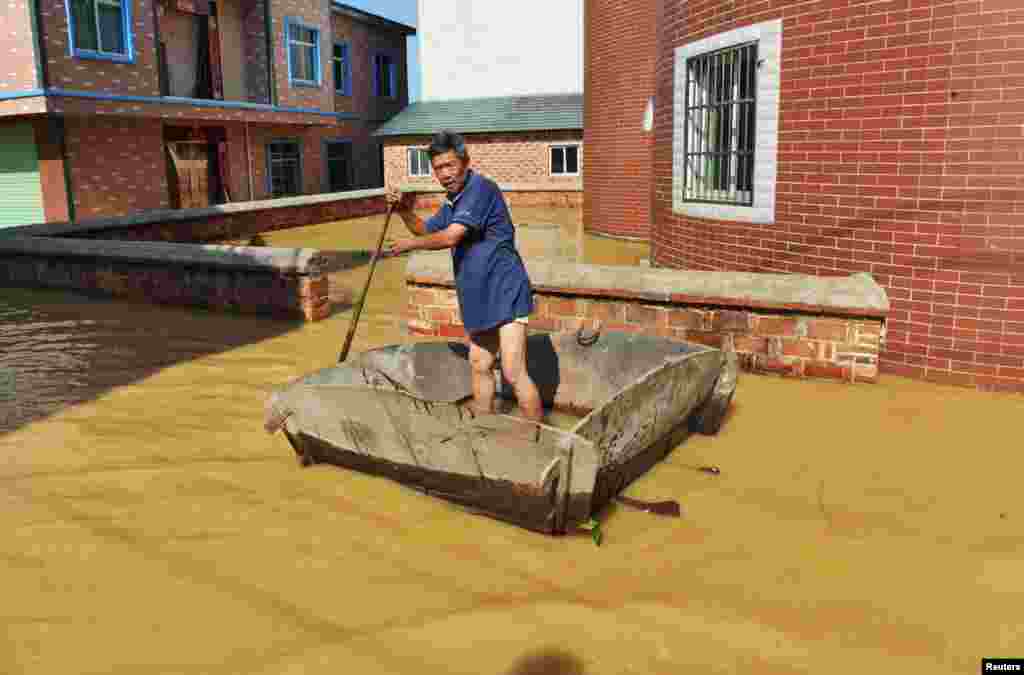 A man rows along a flooded pedestrian area in Poyang County, Jiangxi province, China, June 21, 2016.