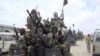 FILE - Al-Shabab fighters display weapons as they conduct military exercises in northern Mogadishu, Somalia.