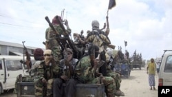 FILE - Al-Shabab fighters display weapons as they conduct military exercises in northern Mogadishu, Somalia.