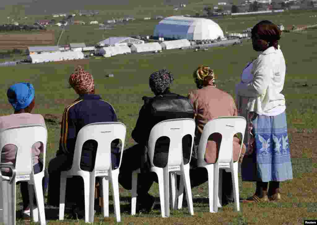 Local women sit at a public viewing point near the burial ground of Nelson Mandela ahead of his funeral in Qunu, Dec. 15, 2013. 