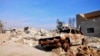 FILE - A burned out car lies amid damaged buildings in Ramadi, 70 miles (115 kilometers) west of Baghdad, Iraq, on Jan. 2, 2016.