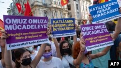 Demonstrators hold a placard reading "Struggle Shoulder to Shoulder" on July, 31 2021, in Istanbul, as they protest one day after seven people from a Kurdish family were shot dead by armed assailants at their home in Turkey's Konya province.