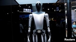 资料照片：特斯拉机器人于2023年7月6日在中国上海举行的世界人工智能大会(WAIC)上展示。官媒新华社10月2日表示将出台支持政策，持续推动中国智能网联汽车产业高质量发展。中国智能汽车行业面临着地缘政治阻力以及来自特斯拉等西方同行在改进技术方面的激烈竞争。 (路透社图片)
