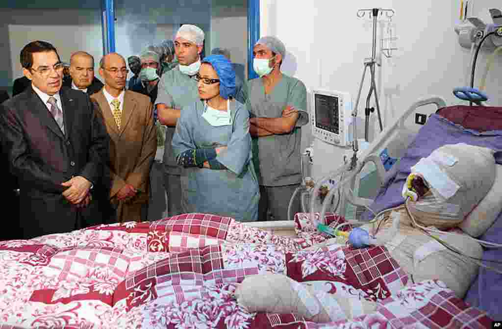 Tunisia's President Zine El Abidine Ben Ali, left, visits Mohamed Bouazizi, a young man who set himself on fire acting out of desperation after police confiscated the fruits and vegetables he sold without a permit, at Ben Arous Burn and Trauma Centre, in