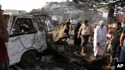 Warga sipil memeriksa lokasi serangan bom di pasar Jameela di daerah Sadr City, Baghdad, Irak (13/8). (AP/Karim Kadim)