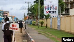 FILE - People walk past the headquarters of Liberia's National Elections Commission (NEC) in the Sinkor neighborhood of Monrovia, Liberia Nov. 6, 2017.