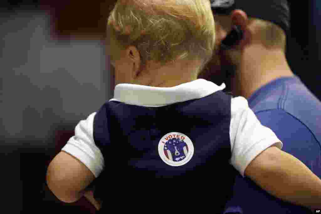 Ethan Deshotel, yang berusia 19 bulan, memakai stiker "I voted" setelah ayahnya A.J. Deshotel memberikan suaranya di TPS St. Dominic's School di Lakeview, New Orleans (8/11). (AP/Gerald Herbert)
