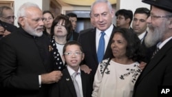 Indian Prime Minister Narendra Modi, left, with Israeli Prime Minister Benjamin Netanyahu, center right, meet with with Moshe Holtzberg, center, an Israeli boy whose parents were killed in the Nov. 26, 2008 terrorist attack on Mumbai, at the King David Ho