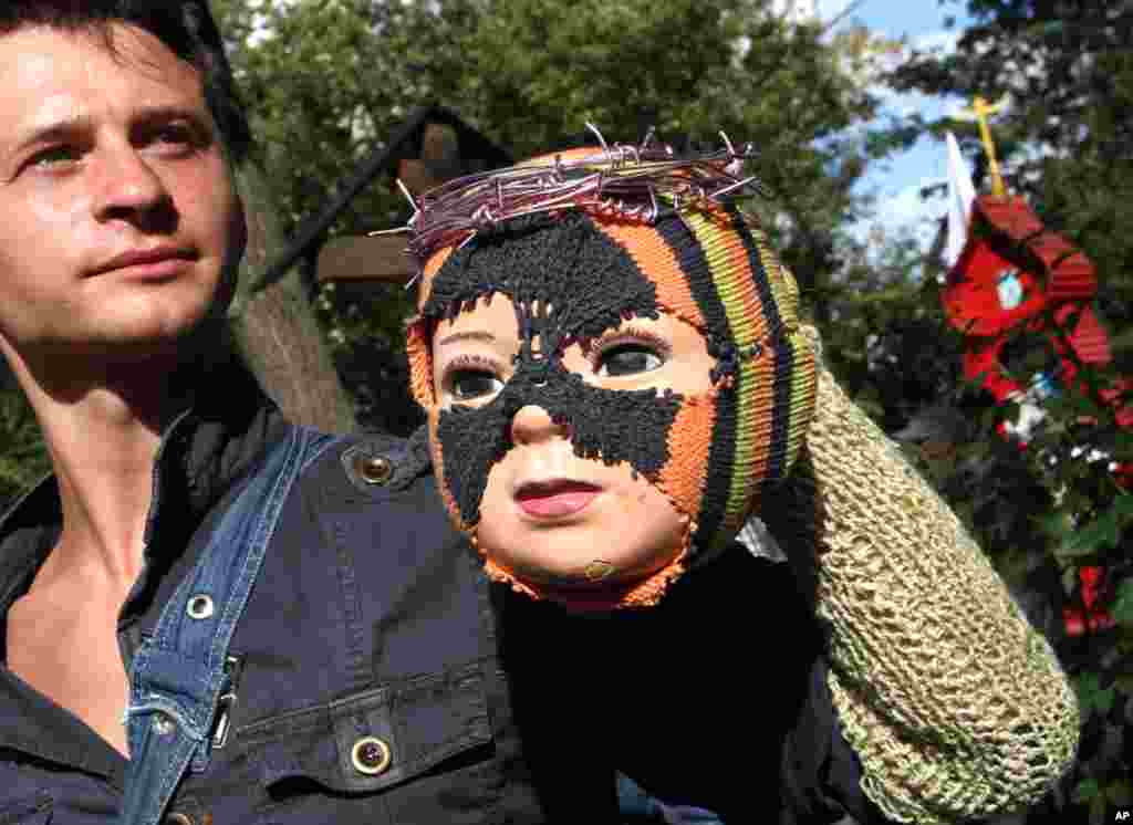 A Russian man holds a doll dressed like a member of the band at an opposition rally in downtown Moscow.