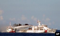越南海岸警卫队公布的照片显示一艘中国海警船（右）在越南海岸外用水炮攻击一艘越南船（资料照片）