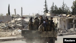 Des rebelles passent des bâtiments en ruine dans la ville d'al-Rai, au nord d'Alep, Syrie, le 2 octobre 2016. 