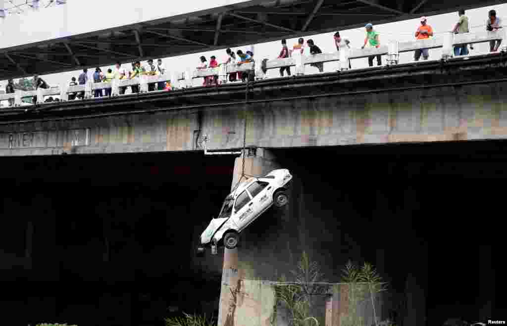 A taxi hangs beside a bridge during a metro-wide earthquake drill, along main highway EDSA in Makati, Metro Manila, the Philippines.