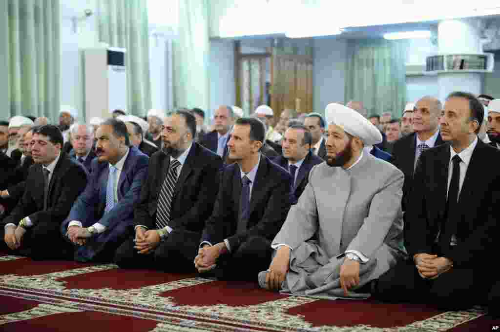 Syrian President Bashar Assad prays at the start of Eid al-Fitr at the Anas bin Malik Mosque, Damascus, August 8, 2013.