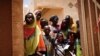 FILE - Local women and children arrive at an abandoned clinic to receive medical care from the French military during Operation Barkhane in Ndaki, Mali, July 29, 2019. 