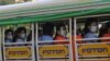 Factory workers wearing protective face masks and shields ride a truck as they go to their works in Hlaing Tharyar Industrial Zone Monday, Oct. 12, 2020, on the outskirts of Yangon, Myanmar. Myanmar government allowed Monday to resume Cut-Make-Pack …