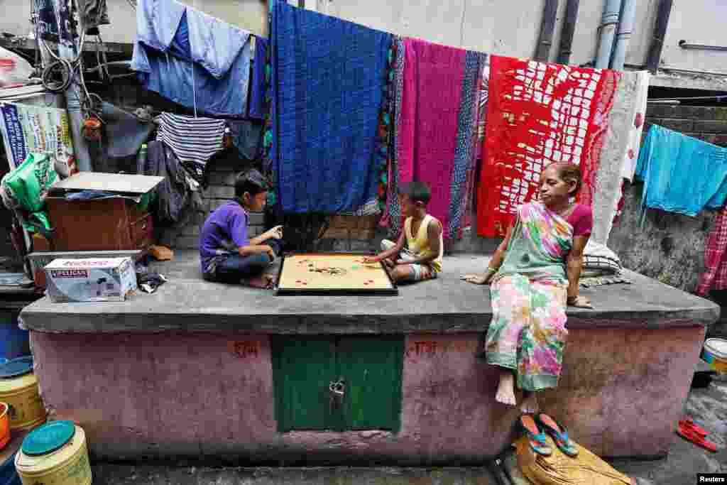 Boys play carrom at a slum area in Kolkata, India.