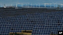 FILE - Solar panels and windmills work near the small town of Milagro, Navarra Province, northern Spain, Feb. 24, 2023. (AP Photo/Alvaro Barrientos, File)