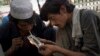 FILE - Pakistani drug addicts smoke heroin in Rawalpindi, June 26, 2013. 