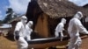 Health workers carry the body of a woman suspected of contracting the Ebola virus in Bomi county situated on the outskirts of Monrovia, Liberia, Monday, Oct. 20, 2014. Liberian President Ellen Johnson Sirleaf said Ebola has killed more than 2,000 people in her country and has brought it to "a standstill," noting that Liberia and two other badly hit countries were already weakened by years of war. (AP Photo/Abbas Dulleh)