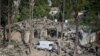 People look at the destroyed houses a day after shelling by Armenian's artillery during fighting over the separatist region of Nagorno-Karabakh, in Ganja, Azerbaijan, Oct. 12, 2020.