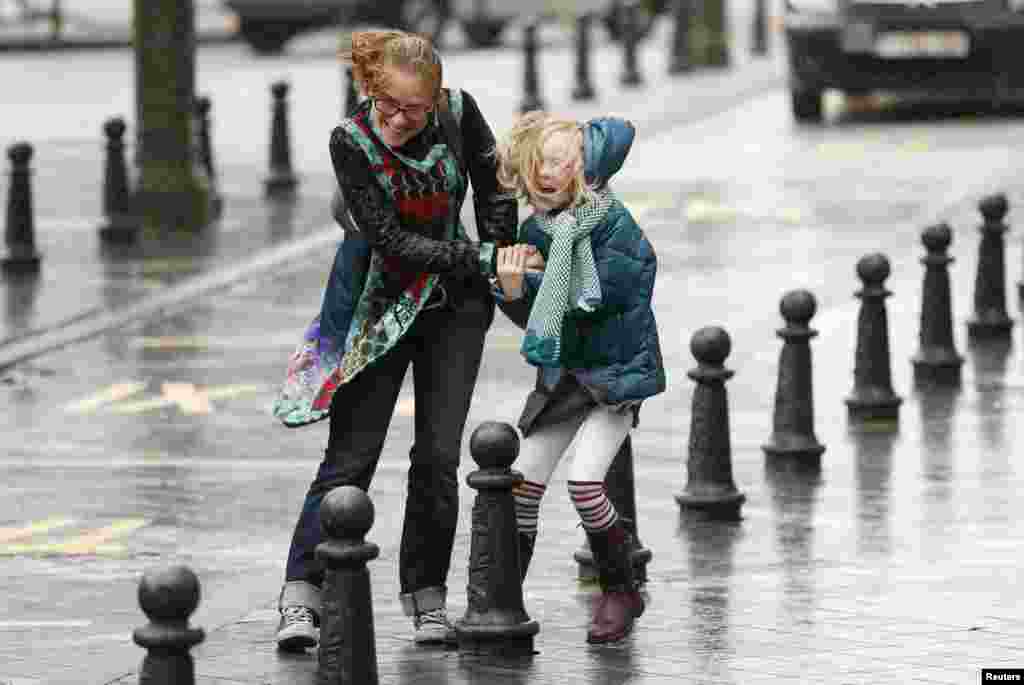A woman and her daughter struggle against strong winds and rain in central Brussels, Belgium. According to local media, the winds could reach speeds of over 100 km per hour (62 miles per hour).