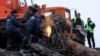 Local workers cut wreckage of the Malaysia Airlines Flight MH17 at the site of the plane crash near the settlement of Grabovo in the Donetsk region, Nov. 16, 2014.