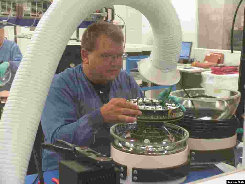 Seorang teknisi di Lab Ilmu-Ilmu Fisika di University of Wisconsin-Madison bekerja pada salah satu sensor di detektor IceCube. (IceCube/NSF)