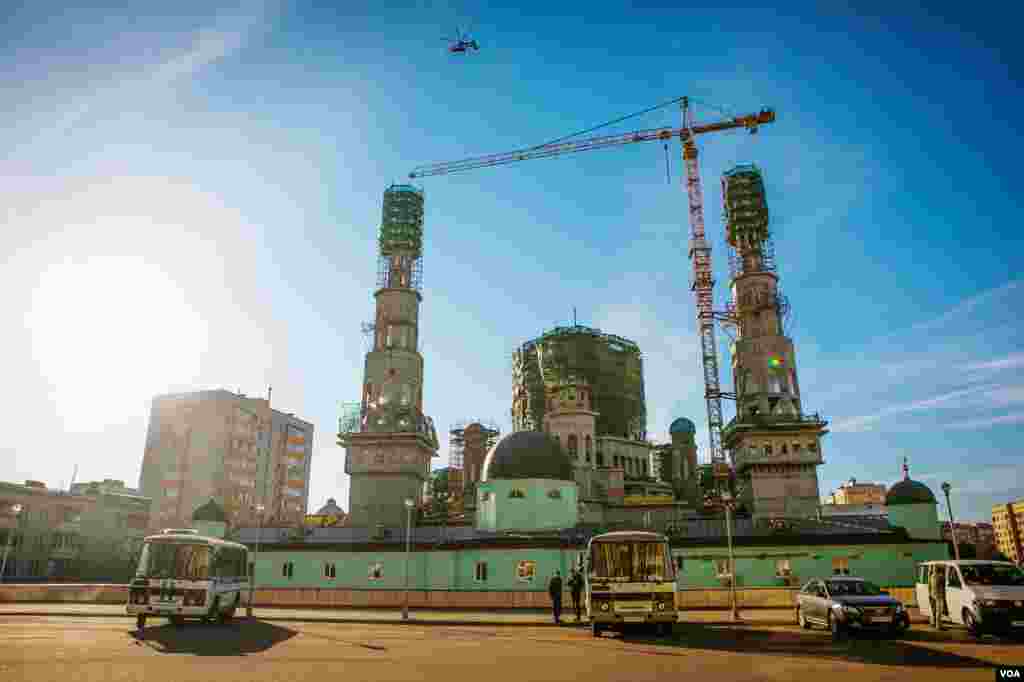 Menara kembar Masjid Katedral yang sedang direnovasi di Moskow menjulang di atas madrasah yang dicat hijau, yang konstruksinya dibuat pada 1904. (VOA/Vera Undritz)