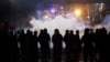 Riot police fire tear gas at supporters of the Shiite Hezbollah and Amal groups in Beirut, Dec. 17, 2019. The groups were angered by a video that showed a man insulting Shiite figures.