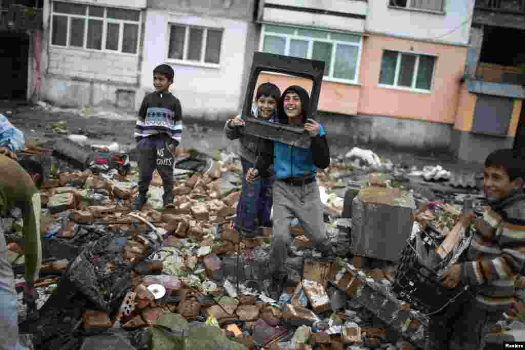 Anak-anak Bulgaria Roma berpose ketika difoto saat mereka menyelamatkan barang-barang yang masih bisa digunakan dari bangunan yang dihancurkan di pinggiran Roma di kota Plovdiv. Pejabat berwenang di wilayah itu mulai menghancurkan sekitar 50 bangunan ilegal yang terdiri dari rumah-rumah dan toko-toko di wilyah itu. 
