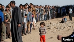 Mutanen Mosul da suke layi domin karbar abincn da gwamnatin Iraqi take ba wadanda yakin ya yashesu kakaf