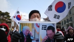 Pristalica opozvanog južnokorejskog predsjednika Yoon Suk Yeola drži plakat sa Junom i novoizabranim predsjednikom SAD Donaldom Trumpom koji se prevodi kao "Reagovao je slanjem svojih posebnih pozdrava narodu Južne Koreje", u Seulu 6. januara 2025.