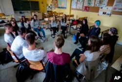 Laura Schulmann, center right, and Sophie Steiert, center left, listen to questions from students about Jewish daily life in Germany during a lesson as part of a project about religions at the Bohnstedt Gymnasium high school in Luckau, Germany, June 25, 2018.