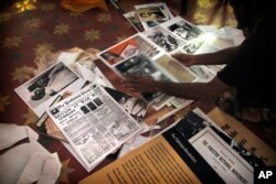 A worker sorts through photographs, newspaper clippings, and other material, Aug. 12, 2017, that will cover the walls at the Partition Museum, set to open in Amritsar, India, 32 kilometers (20 miles) from the border with Pakistan.