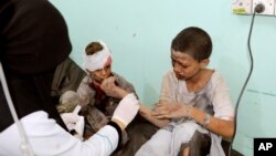 A doctor treats children injured by an airstrike in Saada, Yemen Aug. 9, 2018.