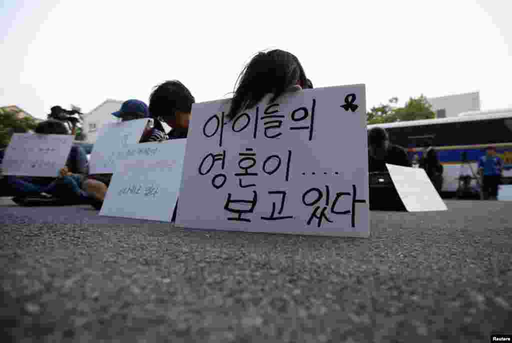 Para anggota keluarga korban tenggelamnya kapal feri Sewol di depan sebuah bangunan tempat awak kapal ditahan, usai menghadiri sidang pengadilan Gwangju, Korea Selatan (10/6).
