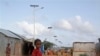 A Somali child stands under the solar powered lights at a refugee camp that were installed to help combat the rampant rapes that were occurring at night, in Mogadishu, Somalia, July 17, 2013.