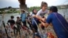 Migrants from Venezuela make their way through the razor wire after crossing the Rio Grande into the United States in Eagle Pass, Texas, Sept. 26, 2023.