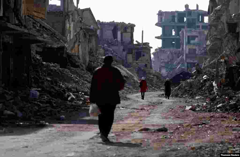 시라아 다마스쿠스의 &#39;야묵(Yarmouk)&#39; 팔레스타인 난민 캠프의 부서진 건물들 사이로 사람들이 걷고 있다. 