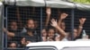 Migrants ride on a truck as they are transferred from a temporary detention facility to a naval base on Langkawi island, Malaysia, on Wednesday, May 13, 2015.