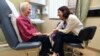 In this March 4, 2019 photo, Dr. Allison Magnuson, left, speaks with patient Nancy Simpson at the Pluta Cancer Center in Rochester, N.Y.
