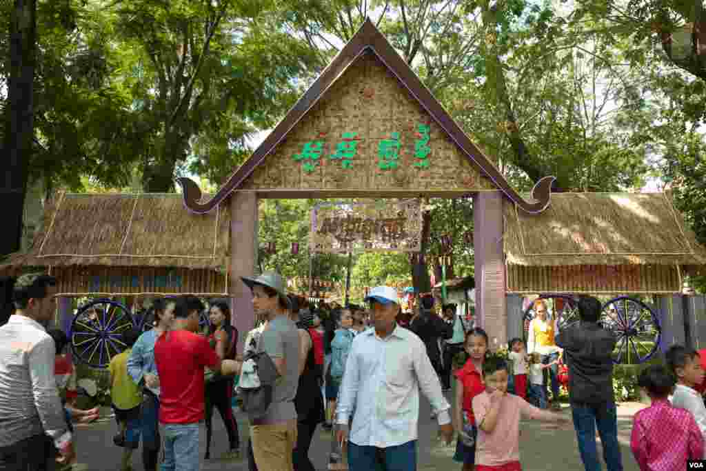 ប្រជាជនខ្មែរដើរនៅខាងមុខក្លោងទ្វារសង្រ្កាន្តនៅរមណីយដ្ឋានវត្តភ្នំ អំឡុងកម្មវិធីសង្រ្កាន្តវត្តភ្នំដើម្បីអបអរពិធីបុណ្យចូលឆ្នាំប្រពៃណីខ្មែរនៅក្នុងថ្ងៃទីពីរ កាលពីថ្ងៃទី១៥ ខែមេសា ឆ្នាំ២០១៩ ក្នុងរាជធានីភ្នំពេញ ប្រទេសកម្ពុជា។(ទុំ ម្លិះ/VOA)